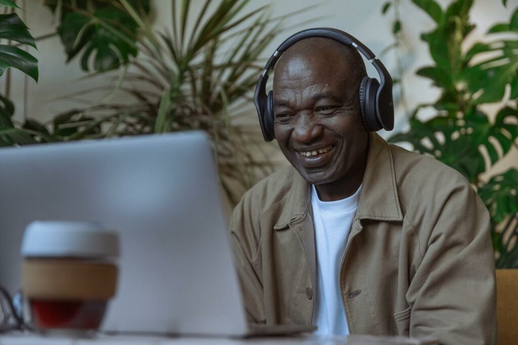 Photo of an old man looking at a laptop and smiling